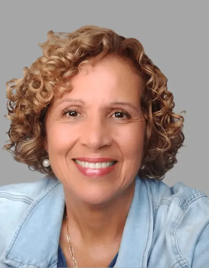 Gilliane smiling, in a denim jacket